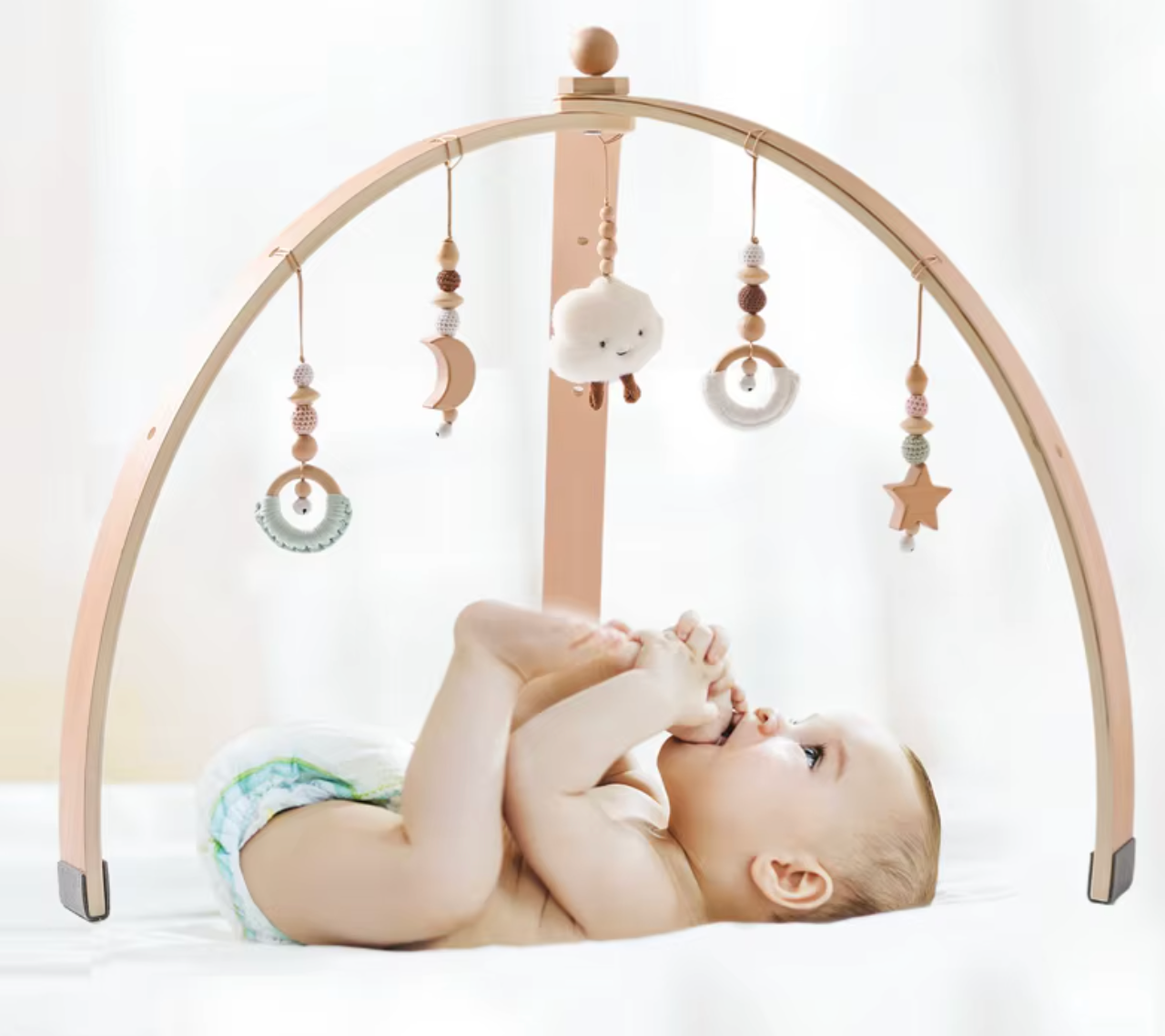 Halvcirkelformat babygym i trä med rymdtema från sidan