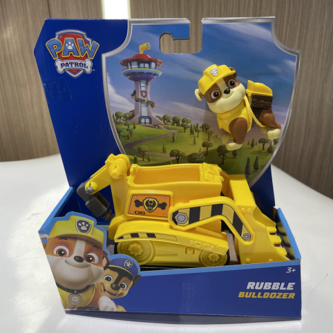 Gul bulldozer med Rubble-figur i förpackning på bord