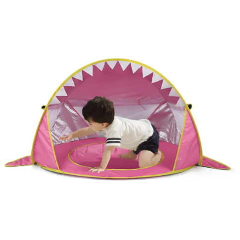 Barn kryper in i rosa hajformat pop up-strandtält
